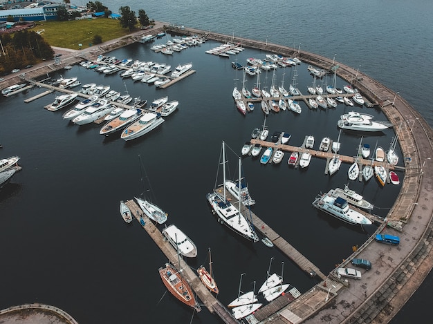 yacht club with a breakwater. Yachts, motor boats, sailboats, berths, piers.