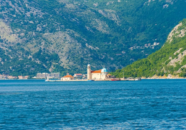 The yacht sails near the picturesque Gospa od Skrpela Island in the Boka Kotorsky Bay