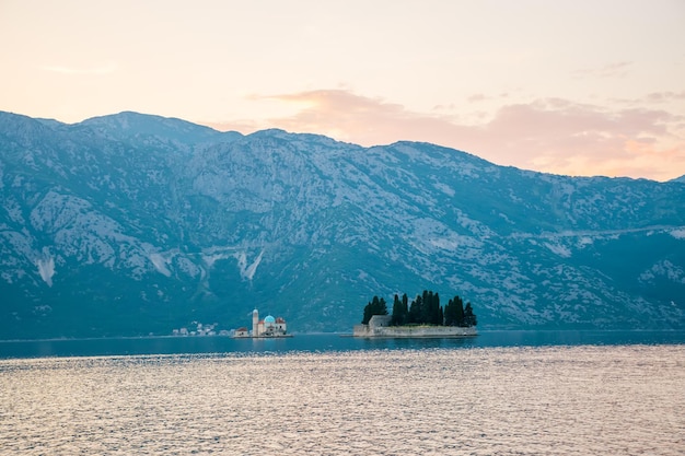 The yacht sails near the picturesque Gospa od Skrpela Island in the Boka Kotorsky Bay