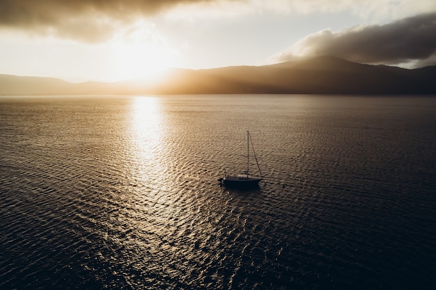 The yacht sails on the ocean at sunset the boat sails near the mountains in brazil