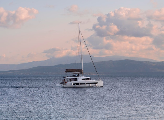 Yacht at sunset on the calm Aegean Sea on island of Evia, Greece