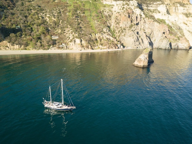 yacht on the water near the rocks aerial. High quality photo