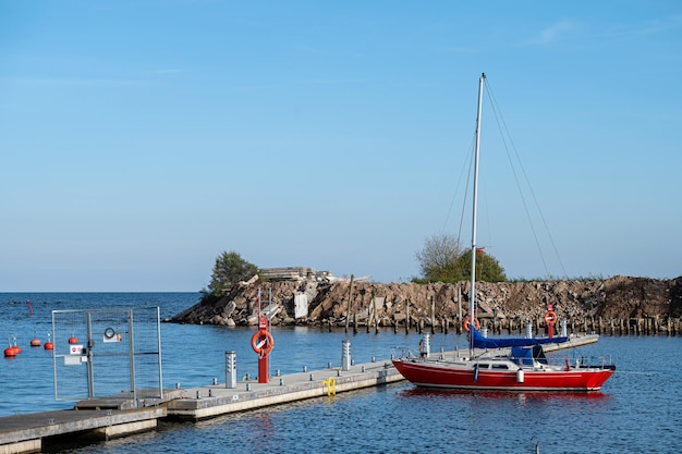 Yacht at a wooden platform in the port of Engure on the coast of the Baltic Sea