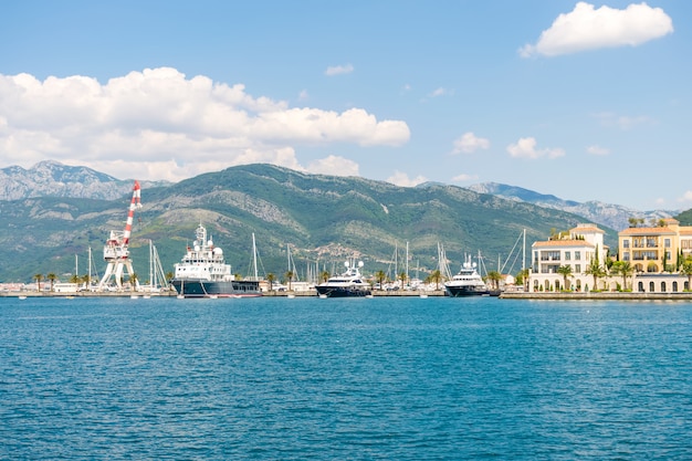 Yachts of various sizes and large vessels moored in the port of Tivat