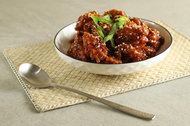 Yangnyeom Tongdak, Korean Fried Chicken with Spicy Sauce and Sesame Seed. Served in the white plate