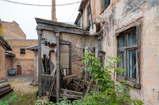 The yard of an residential area with an abandoned crumbling house