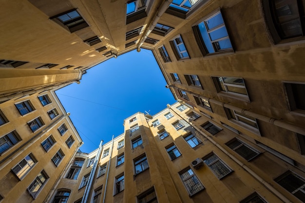 Yardwell of yellow residential buildings closed in a circle with a blue sky in st petersburg