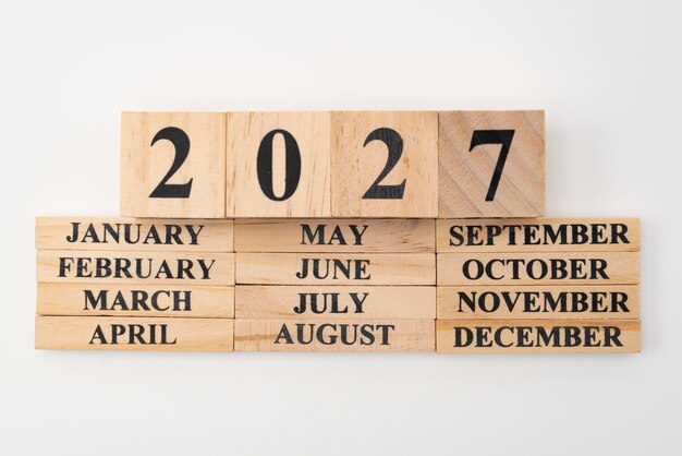 Photo year 2027 written on wooden cubes on top of the months of the year