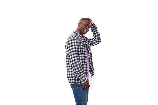 year old african guy dressed in a plaid black and white shirt posing on an isolated background with