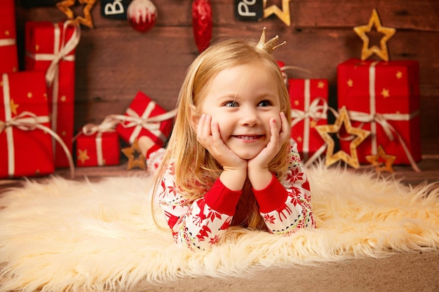 years old girl lies on a soft pillow near gifts at home