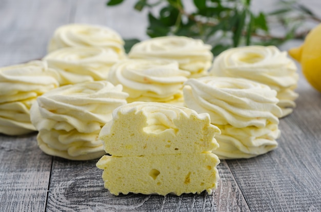 Yellow, apple marshmallow with lemon on wooden vintage background.