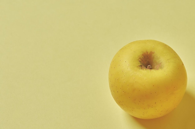 Yellow apple on yellow background