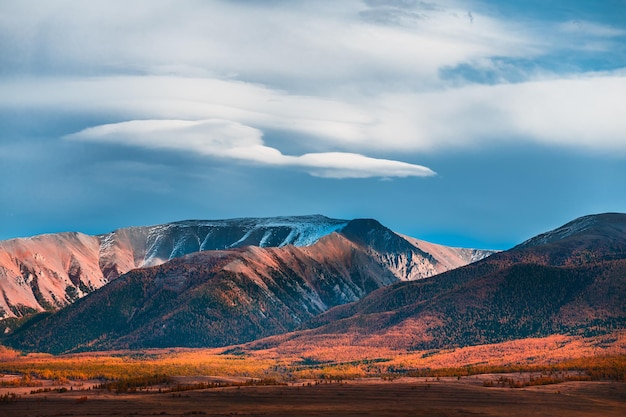 Yellow autumn mountains and blue sky with clouds in Kurai steppe of Altai Russia Autumn landscape