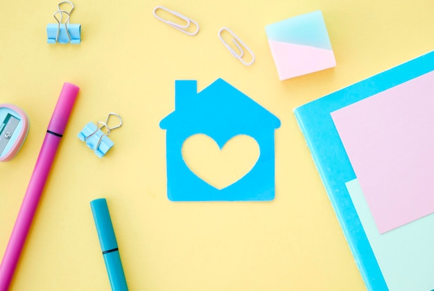 On a yellow background there is a sticker in the form of a house and stationery around Bright layout