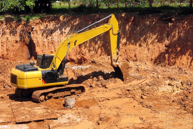 A yellow backhoe is parking in construction site