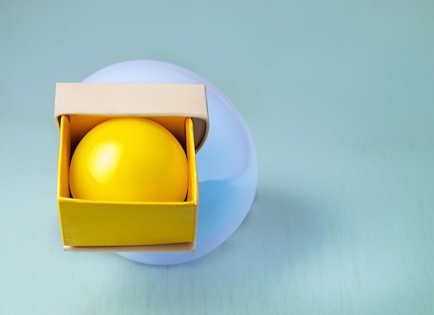 Yellow ball in boxgift or surprise conceptsfunny background