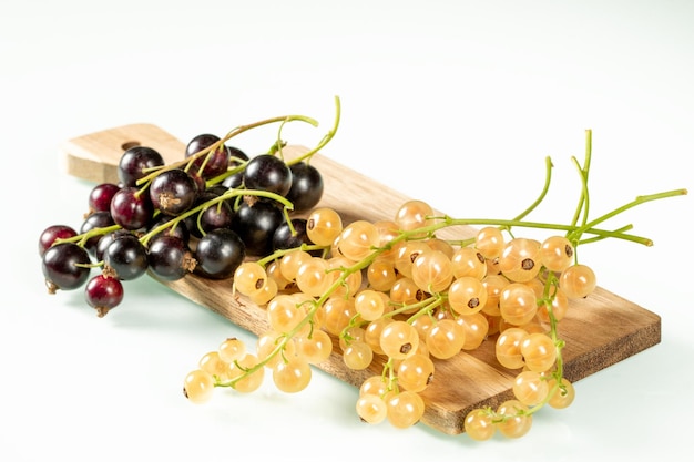 Yellow and black currant clusters on a white background closeup