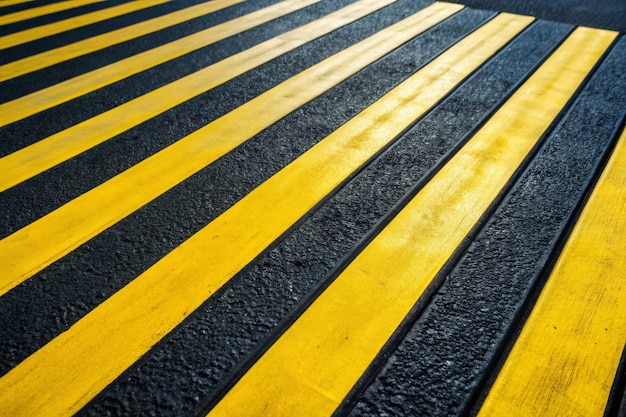 Photo yellow and black pedestrian zebra crosswalk markings on road