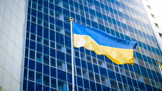 Yellow and blue Ukrainian flag against modern business office building