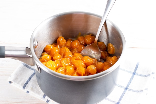 Yellow cherry plum in a saucepan on a light table. Cherry plum for making tkemali sauce