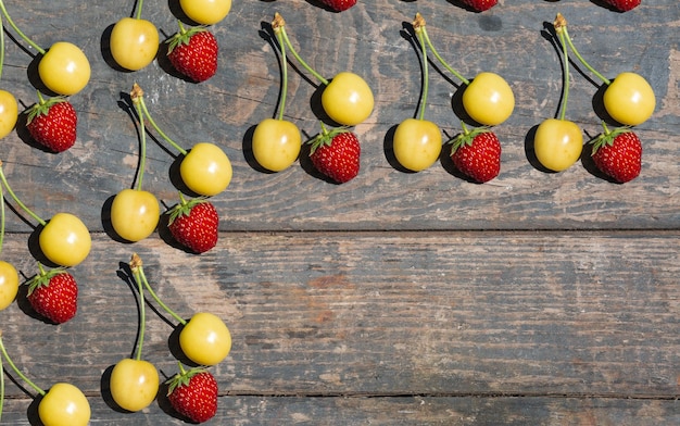 Yellow cherry and red strawberry on wooden texture boards Rural gardening vegetable garden fruits