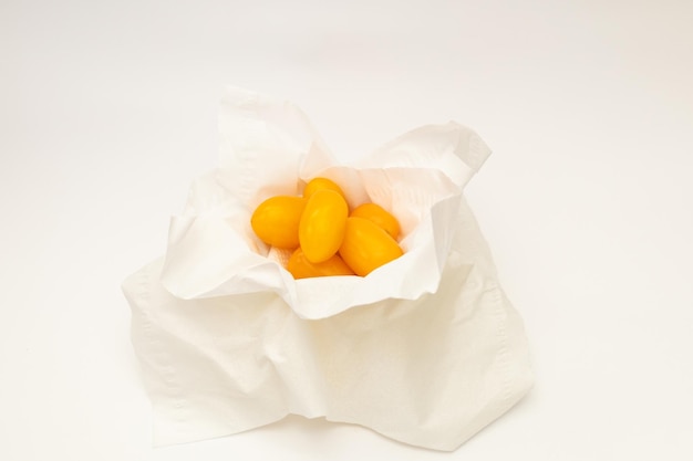 Yellow cherry tomatoes on a white background