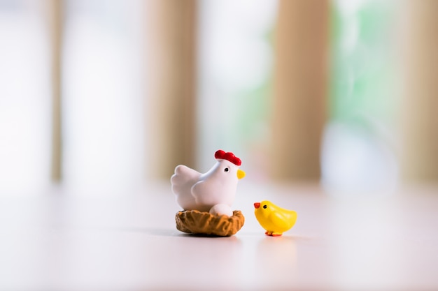 Yellow chicken and hen standing on the nest