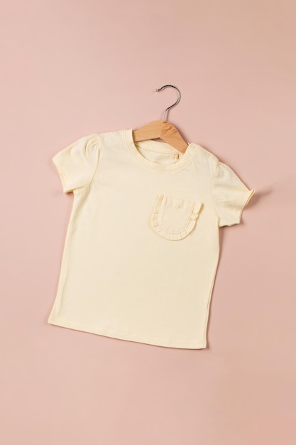 Yellow children39s Tshirt on a pink background Children39s fashion Flat lay