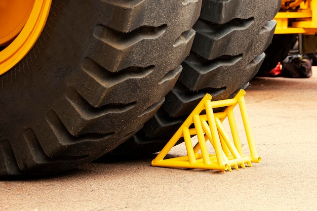 Yellow chock wheel chock under the wheel of a mining truck Brake shoe Security engineering