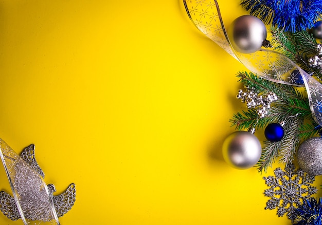 Yellow Christmas background decorated with fir tree and toys