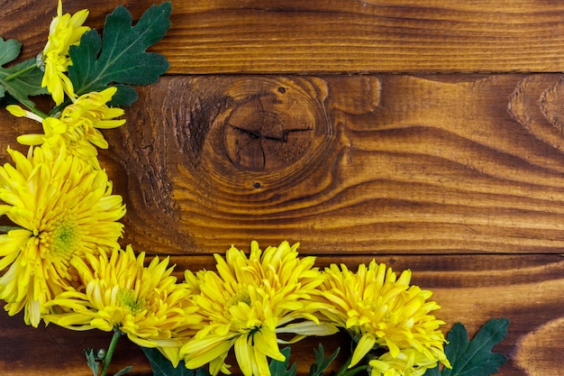 Yellow chrysanthemums on wooden background Top view copy space