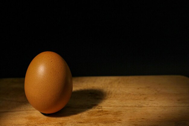 yellow colored egg on black background. Selective focus. Light and shadow.