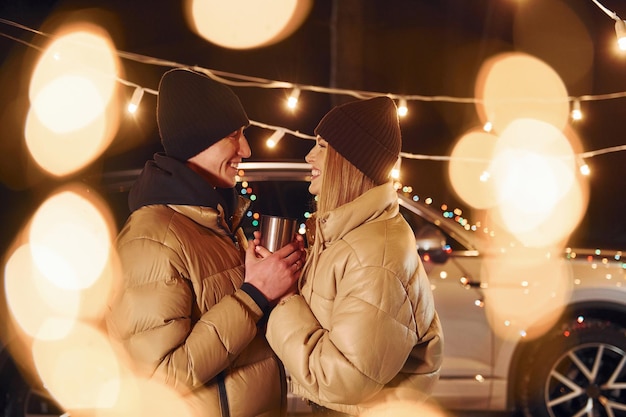 Yellow colored lighting Couple standing in the forest and celebrating New year