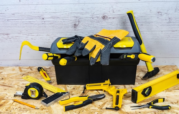 Yellow construction instruments and a tool box on a wooden background