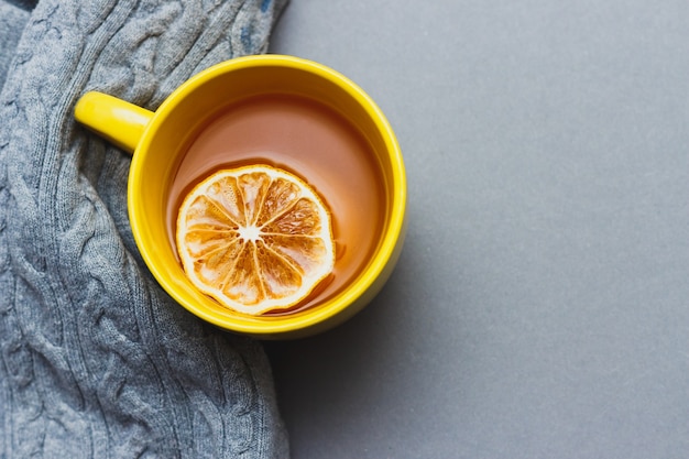 Yellow cup of coffee on gray background with place for text. Bright still life concept with colors 2021. Top view. Copy space.