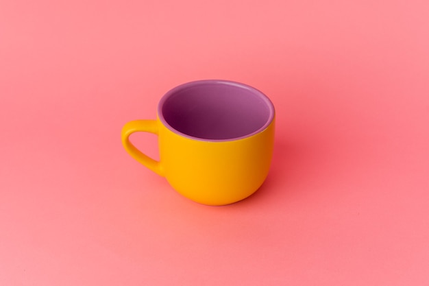 Yellow cup isolated on pink background