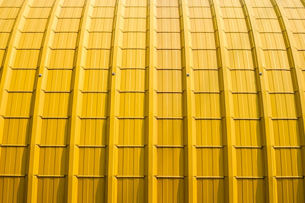 Yellow Curved Corrugated Steel Roof Background with sunlight on surface