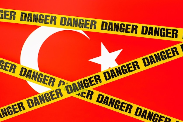 Yellow danger tape with flag of Turkey on the background