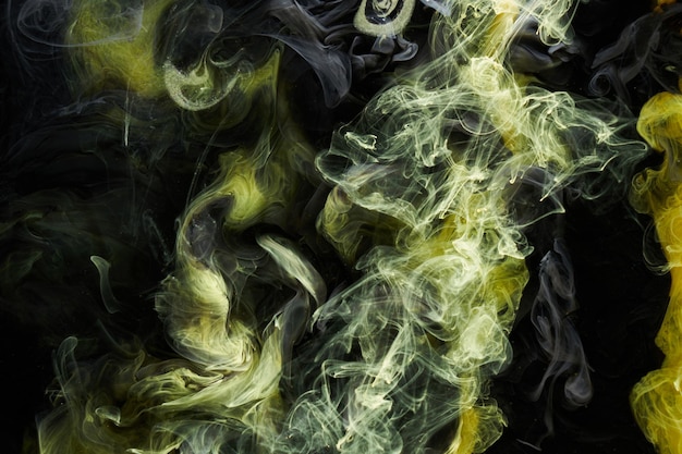 Yellow dark abstract background luxury colored smoke acrylic paint underwater explosion cosmic swirling ink