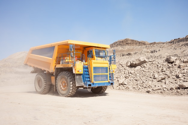 Yellow dump truck moving in a coal mine