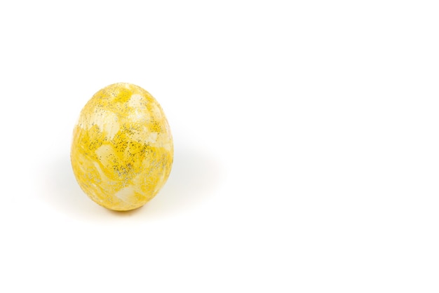 Yellow Easter egg decorated with glitter isolated on a white surface