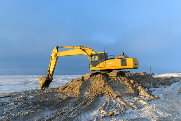 Yellow excavator working on construction site. The road construction.