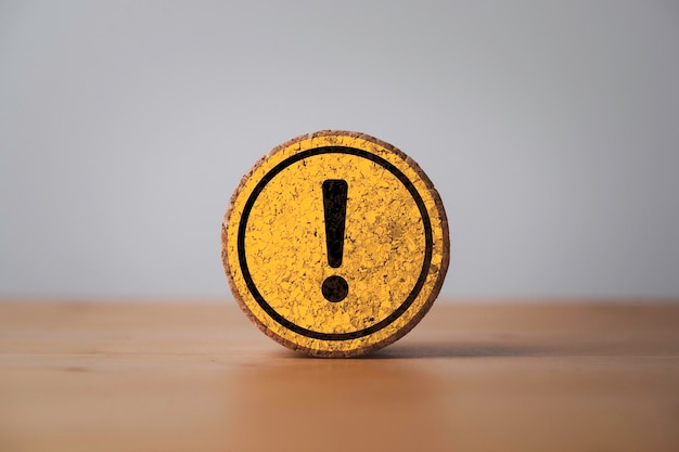 Yellow exclamation caution sign or warning symbol print screen on round wooden block on dark background for notification error and maintenance concept