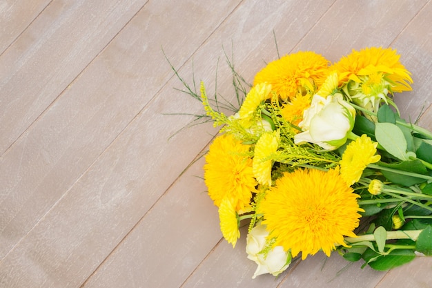 Yellow fall bouquet on wooden table with copy space