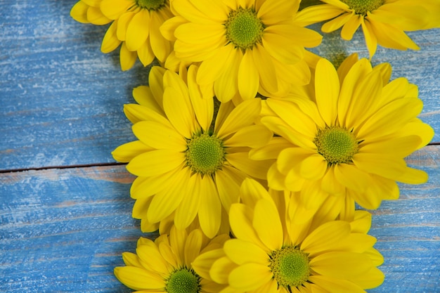 Yellow Flowers over painted wooden background for text