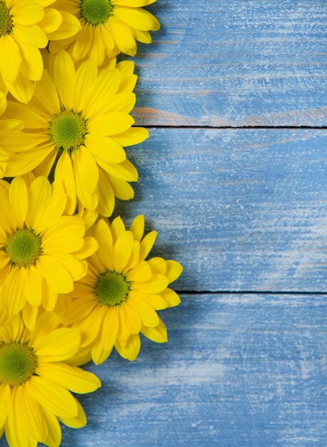 Yellow Flowers over painted wooden background for text