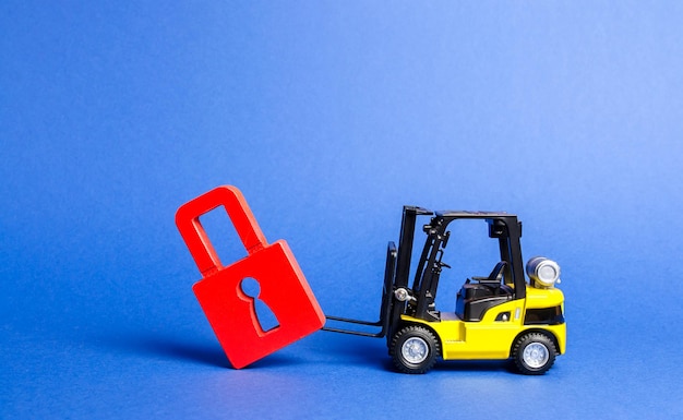 A yellow forklift tilts a red padlock from the road Bypassing prohibitions and sanctions restrictions lobbying the interests of industry in government Loopholes in the laws overcoming bans