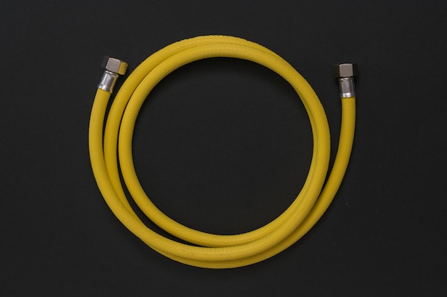 Yellow gas connection hose on a black background