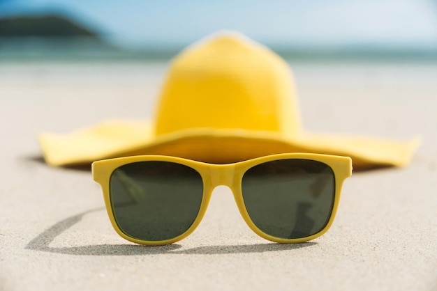 Yellow glasses and hat on the beach