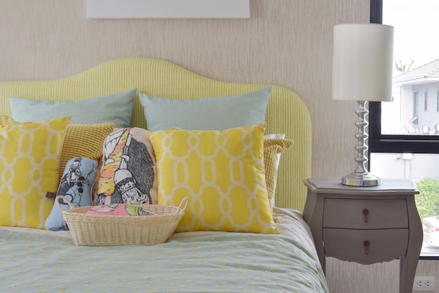 Yellow and green and pattern pillows on classic style bed 